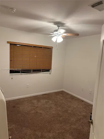 en empty room with windows and fan