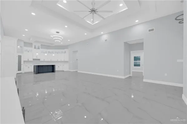 a large white kitchen with a sink and cabinets