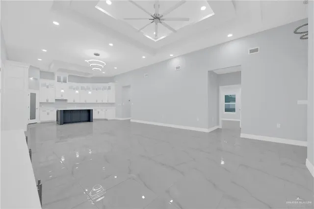 a large white kitchen with a sink and cabinets