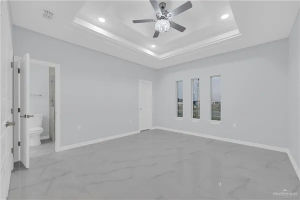 a bathroom with a granite countertop sink a toilet and a mirror