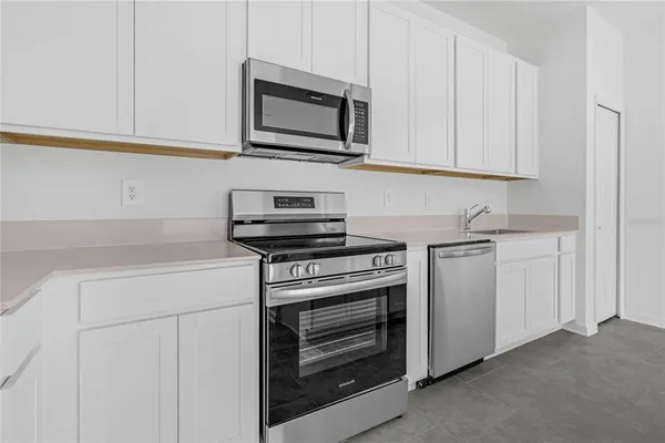 a kitchen with white cabinets stainless steel appliances and sink