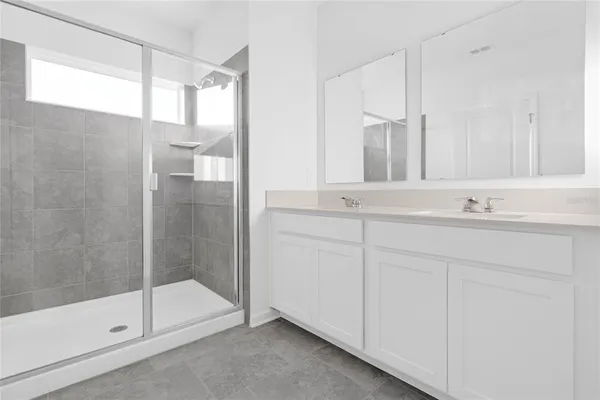 a bathroom with a shower sink and mirror