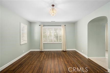 28 Secret Garden Irvine, CA 92620 - Photo 12 of 38 an empty room with wooden floor chandelier fan and windows