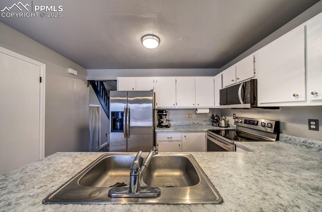 2012 Erin Loop Colorado Springs, CO 80918 - Photo 20 of 48 a kitchen with stainless steel appliances granite countertop a sink a stove and a refrigerator