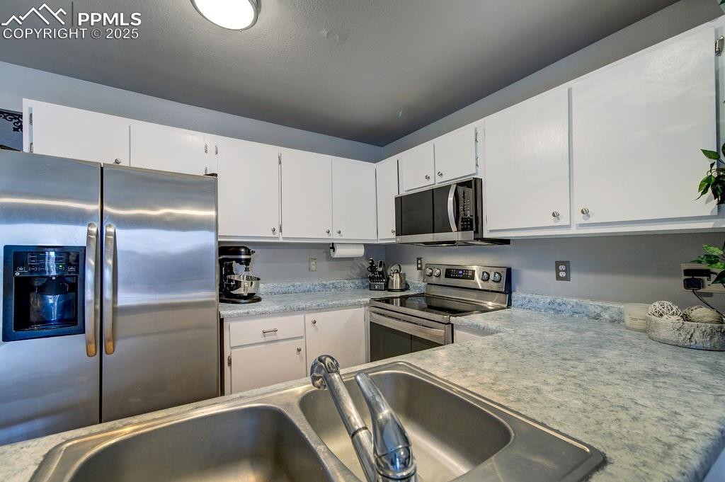 2012 Erin Loop Colorado Springs, CO 80918 - Photo 21 of 48 a kitchen that has a sink and stainless steel appliances
