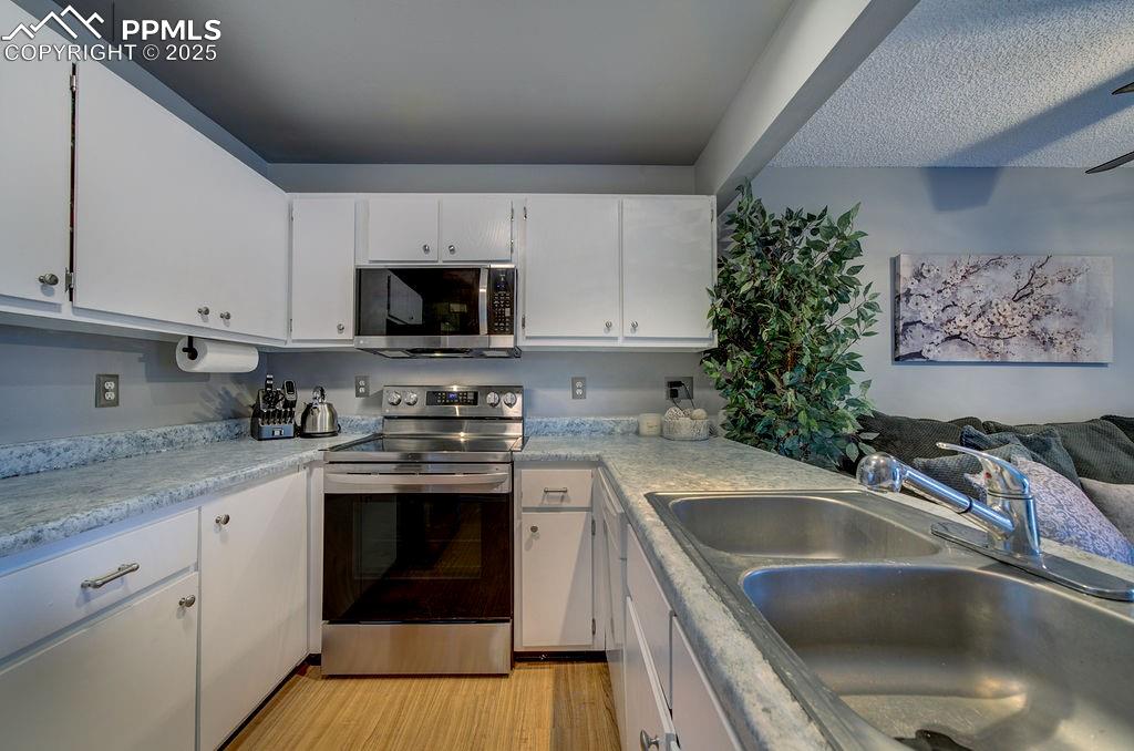 2012 Erin Loop Colorado Springs, CO 80918 - Photo 23 of 48 a kitchen with a sink stove and microwave