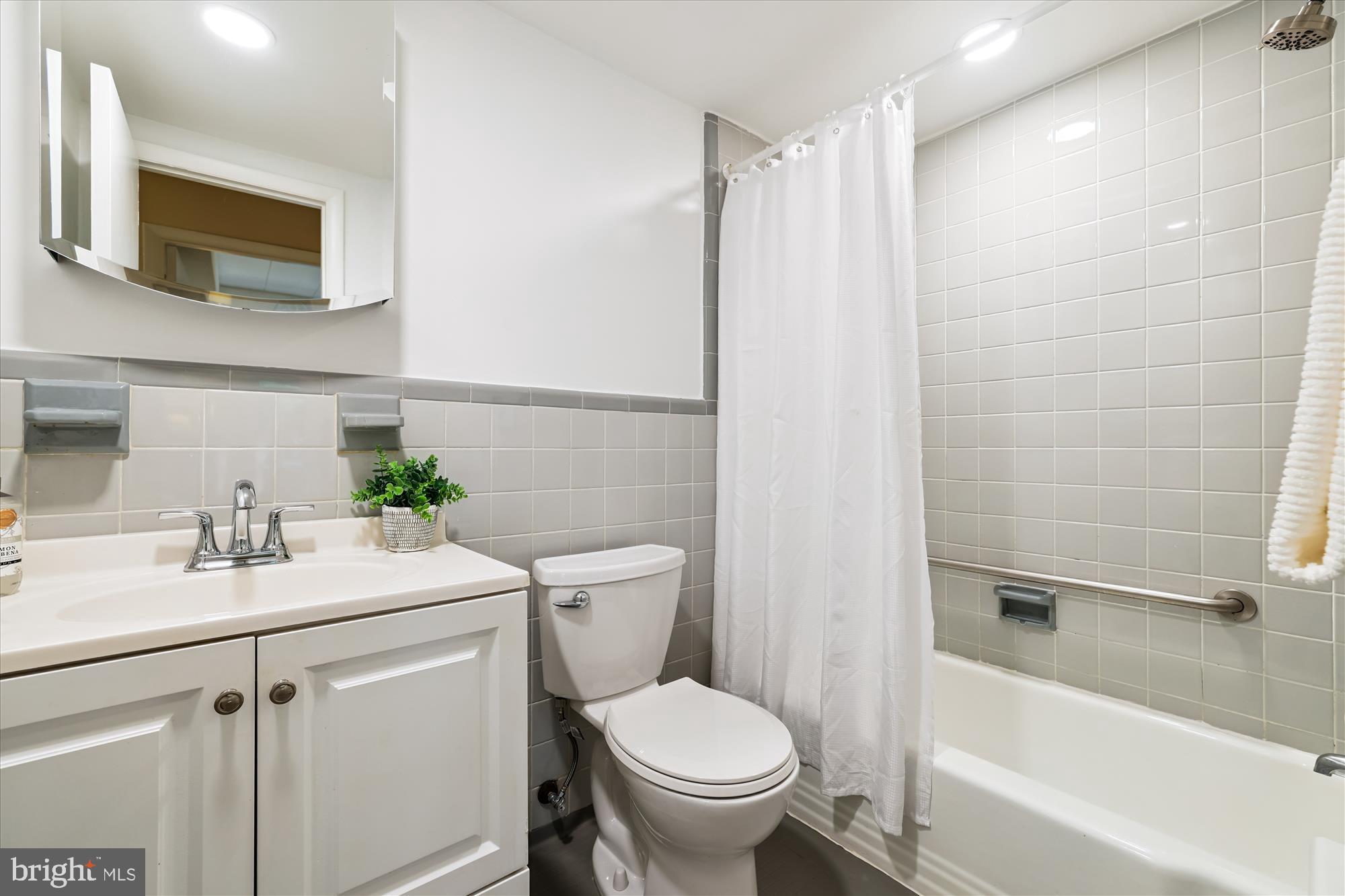 4800 Chevy Chase Drive, Unit 101 Chevy Chase, MD 20815 - Photo 12 of 17 a bathroom with a sink toilet and shower