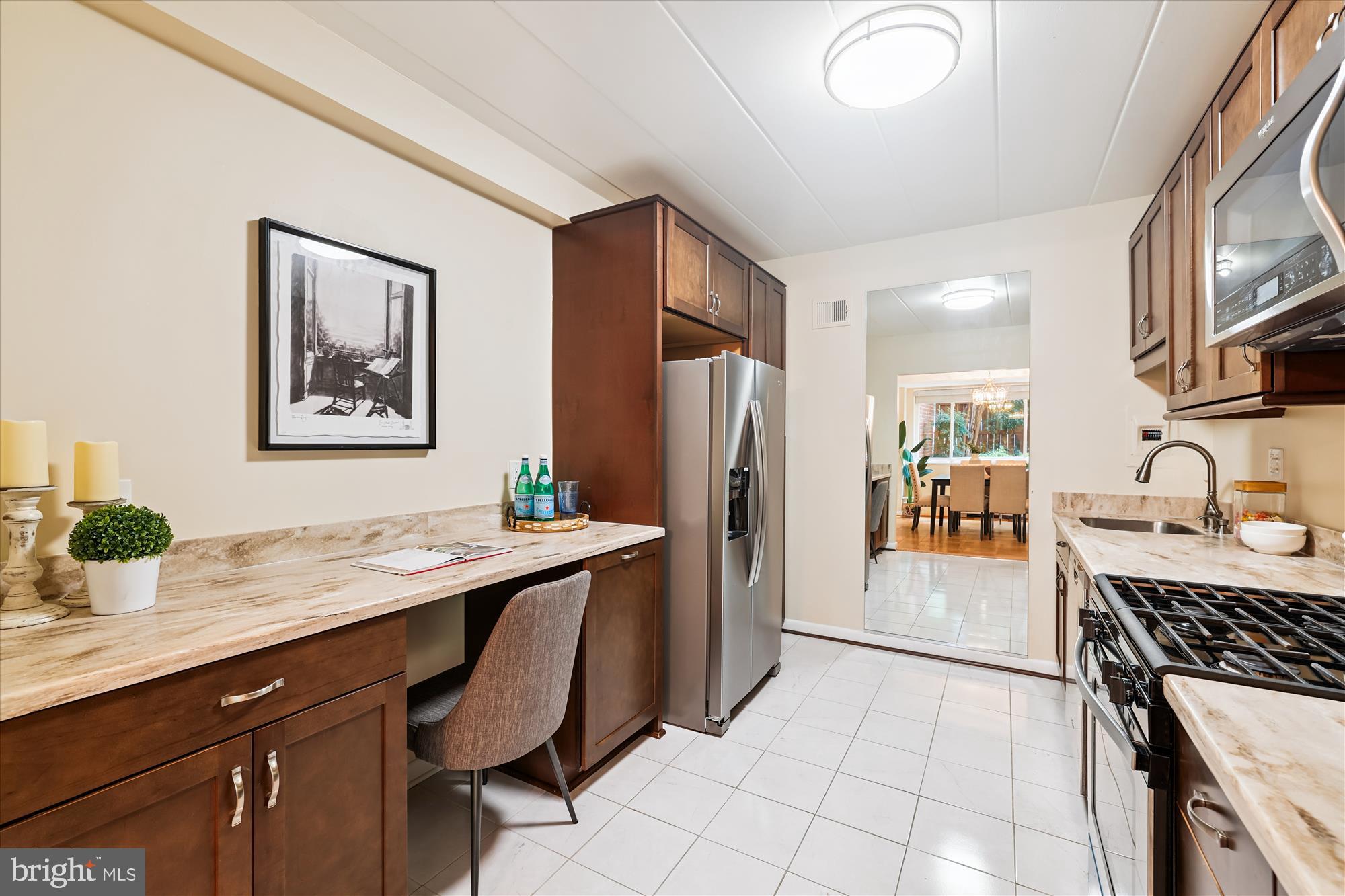 4800 Chevy Chase Drive, Unit 101 Chevy Chase, MD 20815 - Photo 6 of 17 a kitchen with stainless steel appliances a sink and a refrigerator