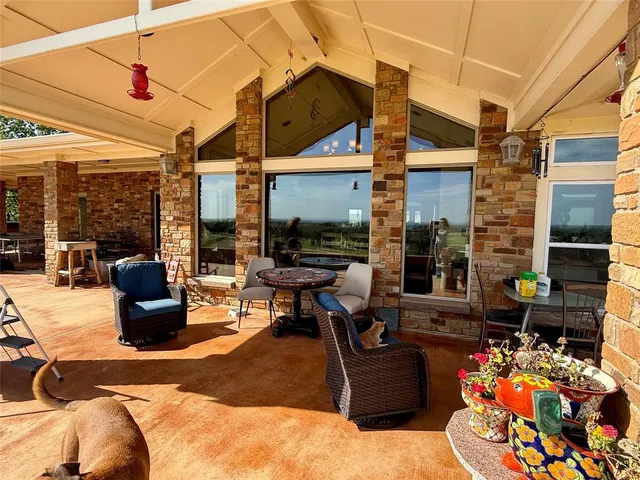 a living room with patio furniture and a floor to ceiling window