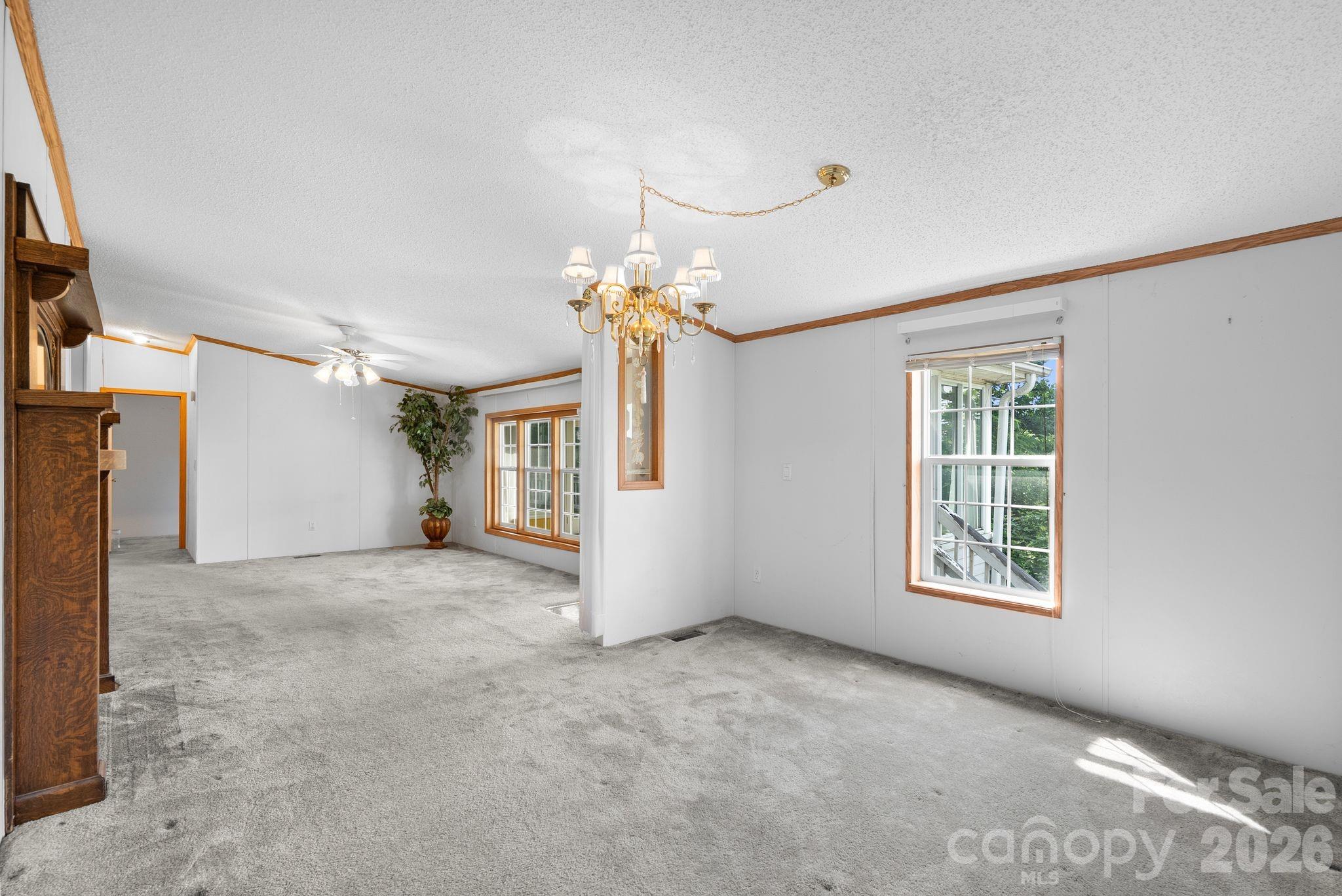 133 Spivey Mountain Road Asheville, NC 28806 - Photo 12 of 40 a view of a big room with windows and chandelier fan