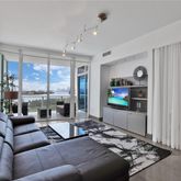 a living room with furniture tv and a large window