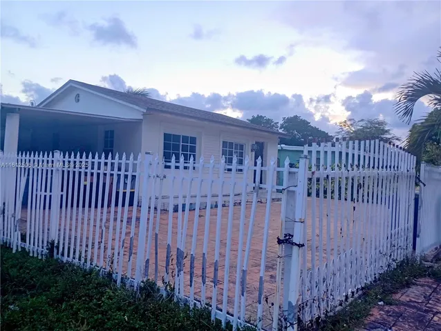 a view of a brick house with wooden fence