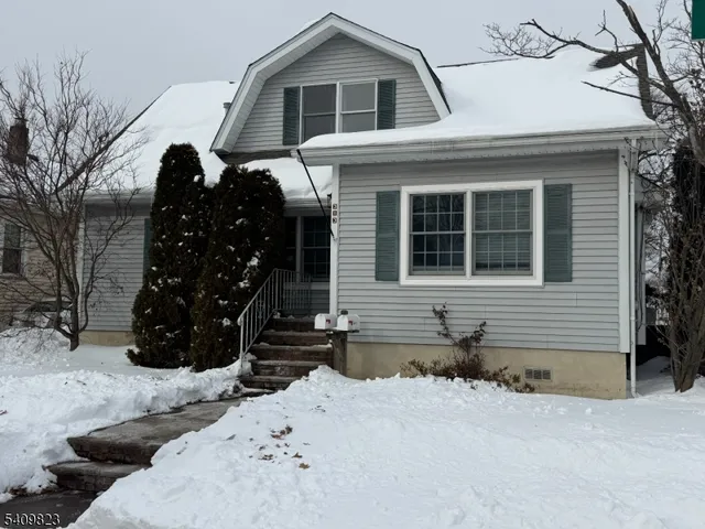 a front view of a house with a yard covered in snow