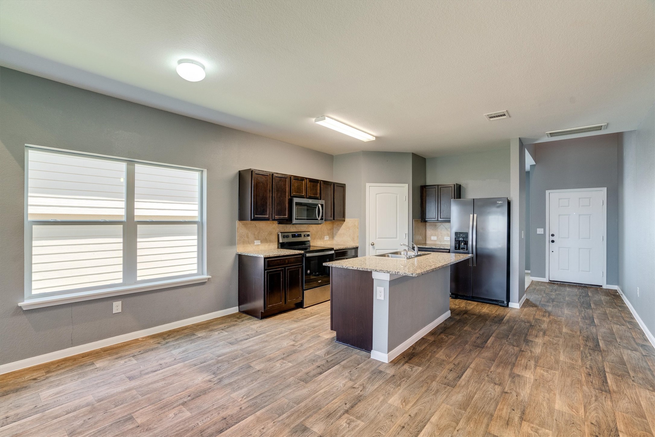 15128 Shell Bark Cove Austin, TX 78724 - Photo 7 of 25 A well-appointed kitchen features rich cabinetry, granite countertops, and modern stainless-steel appliances.