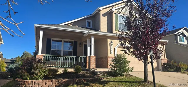 a front view of a house with a tree