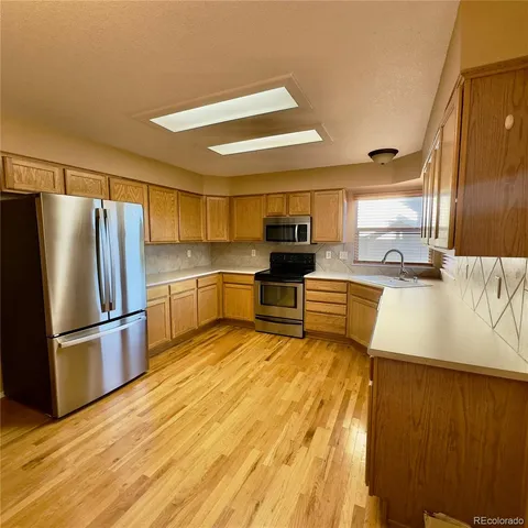 a kitchen with stainless steel appliances a refrigerator and wooden cabinets