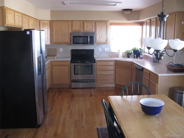 a kitchen with a wooden floor and a refrigerator