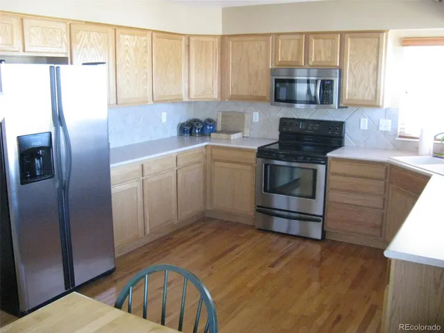 a kitchen with stainless steel appliances granite countertop a refrigerator stove top oven a sink and dishwasher