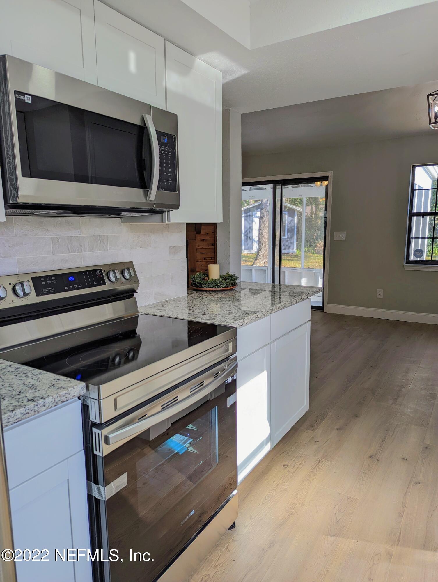 12855 Attrill Road Jacksonville, FL 32258 - Photo 6 of 16 a kitchen with stainless steel appliances a stove microwave and sink