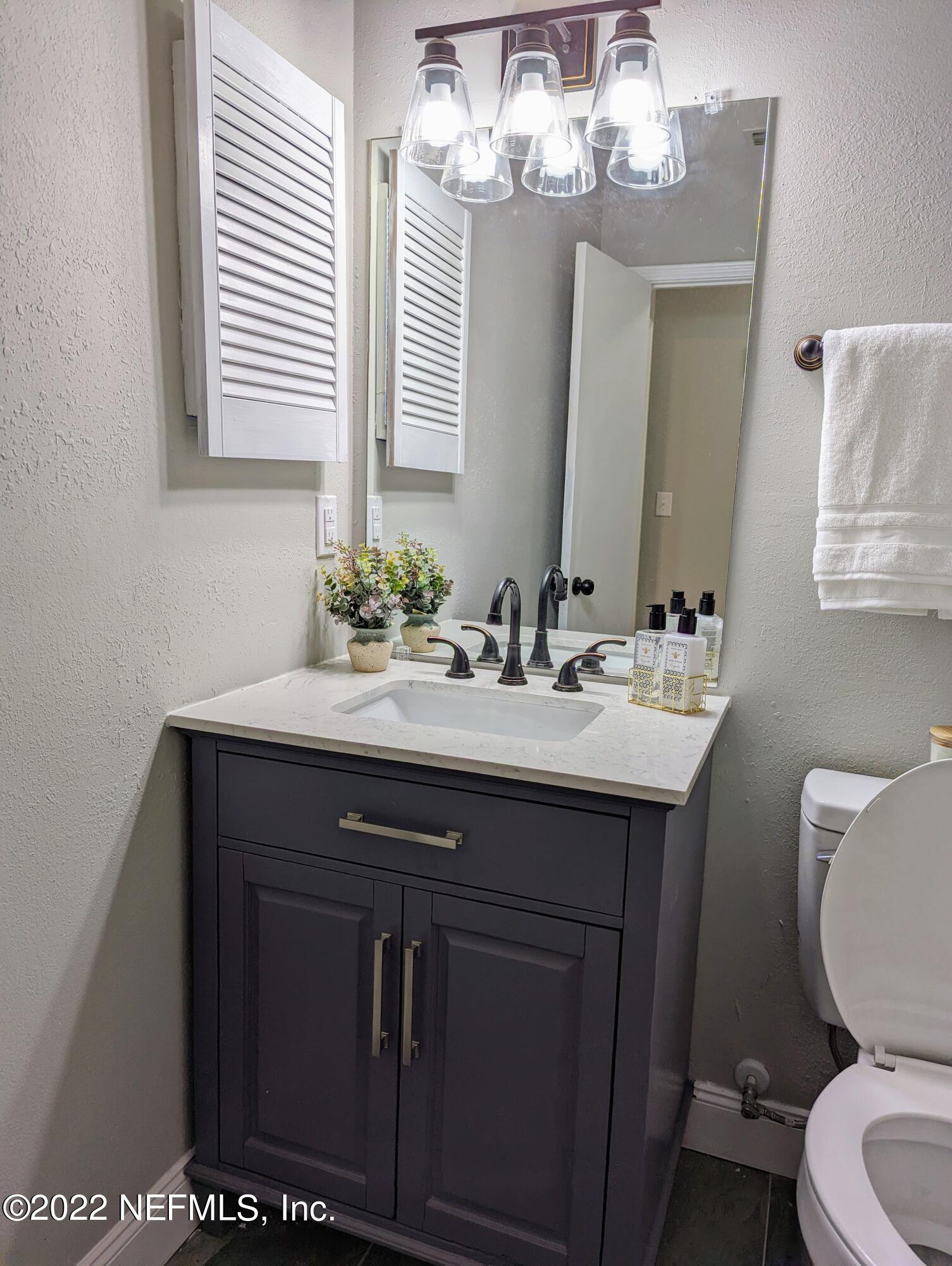 12855 Attrill Road Jacksonville, FL 32258 - Photo 10 of 16 a bathroom with a sink a toilet and a mirror