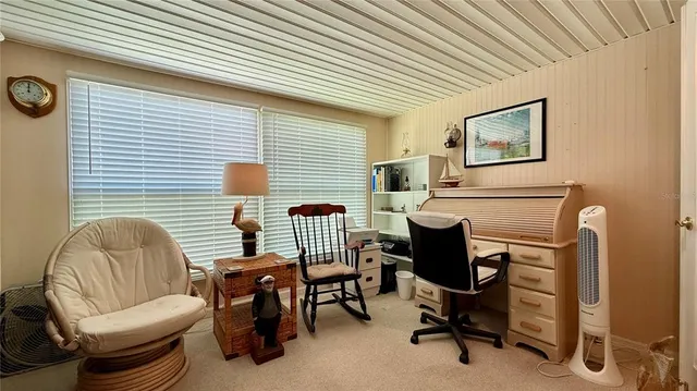 a view of a workspace with furniture and a window