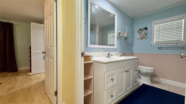 a spacious bathroom with a double vanity sink a mirror and a toilet