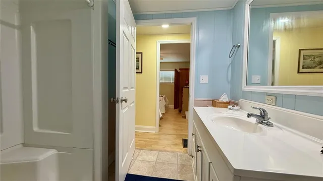 a bathroom with sink shower and mirror