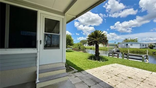 a front view of a house with a yard and lake view