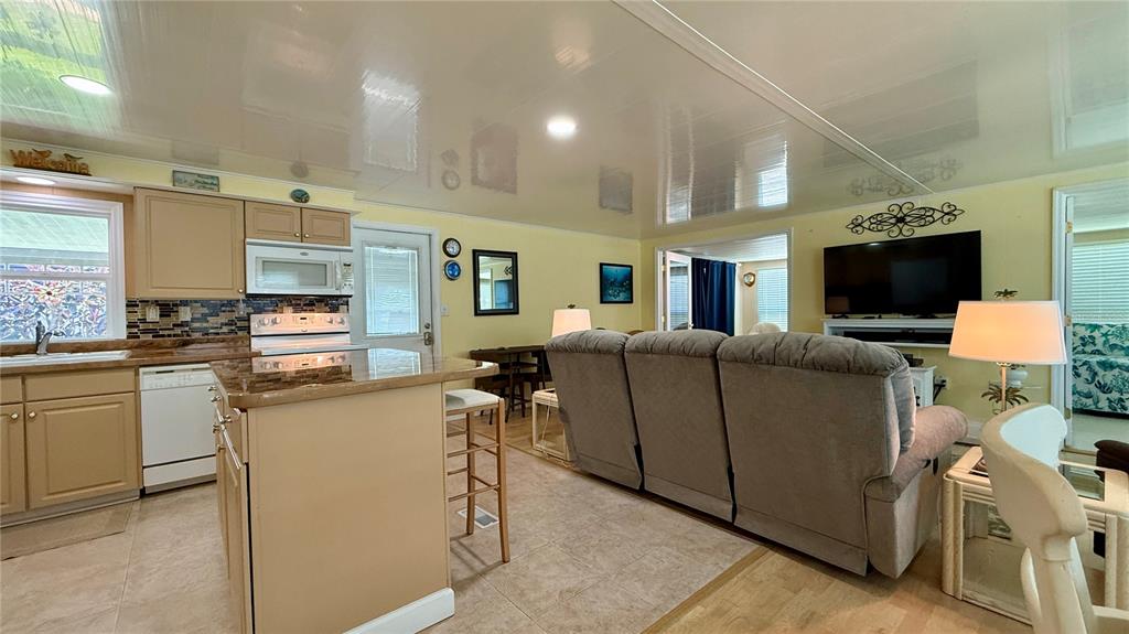 716 Blackburn Boulevard North Port, FL 34287 - Photo 5 of 48 a living room with furniture a flat screen tv and kitchen view