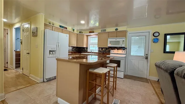 a kitchen with stainless steel appliances kitchen island granite countertop a refrigerator and a stove top oven