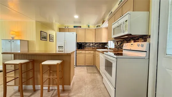 a kitchen with stainless steel appliances granite countertop a sink a stove a microwave a counter top space and cabinets