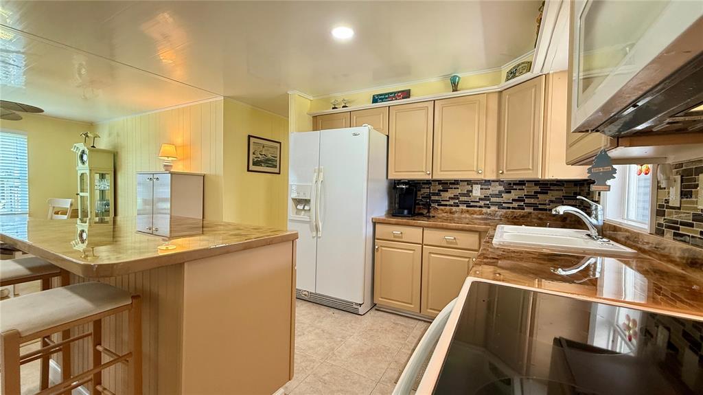 716 Blackburn Boulevard North Port, FL 34287 - Photo 9 of 48 a kitchen with stainless steel appliances a refrigerator a sink and white cabinets
