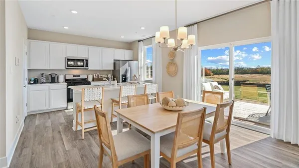 a dining room with stainless steel appliances kitchen island granite countertop a dining table chairs and view kitchen