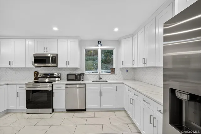 a kitchen with white cabinets appliances and a sink