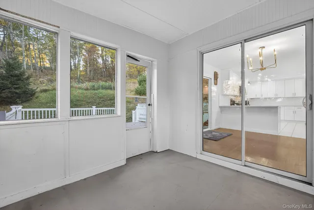 a view of empty room with wooden floor and windows