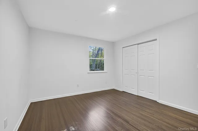 a view of a room with wooden floors and window