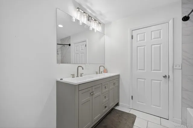 a bathroom with a granite countertop sink a mirror and a shower