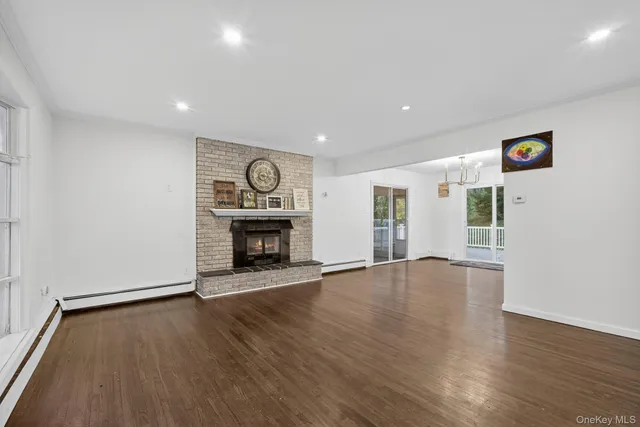 an empty room with wooden floor and a fireplace
