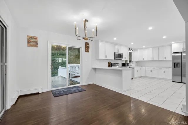 a open kitchen with kitchen island a refrigerator a stove a center island a stove and a wooden floors