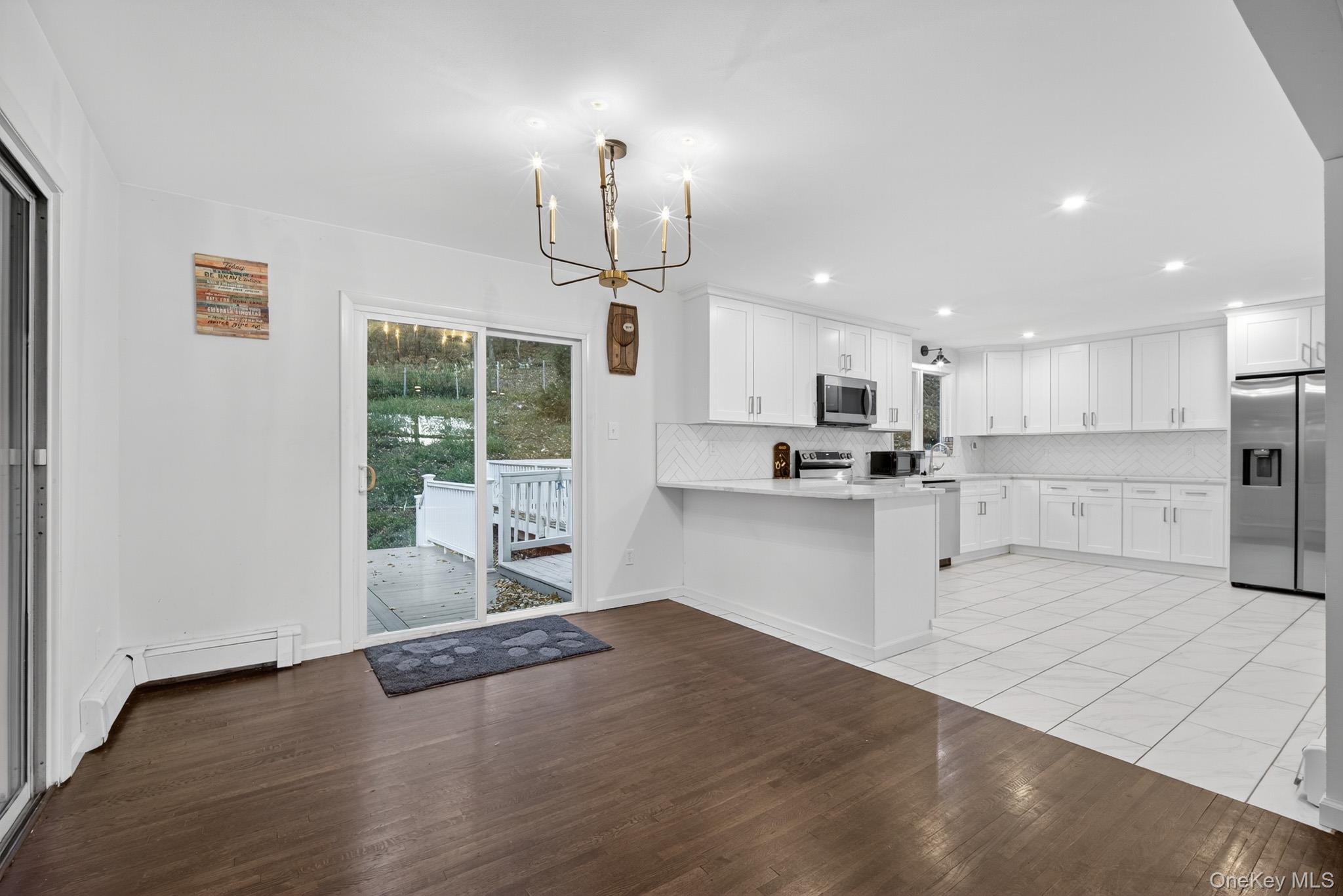 51 Sterling Road Carmel, NY 10512 - Photo 6 of 38 a open kitchen with kitchen island a refrigerator a stove a center island a stove and a wooden floors