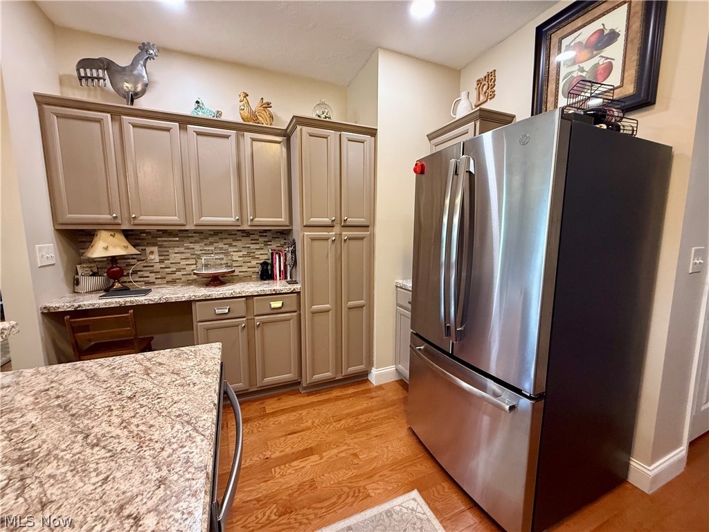 302 Wilcox Road Youngstown, OH 44515 - Photo 25 of 30 Stainless steel French door refrigerator, wood-finish flooring, built-in cabinetry, tile backsplash, and light-toned countertops