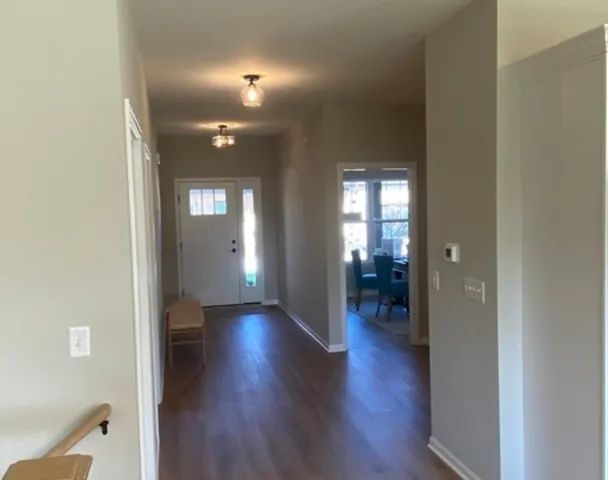 a kitchen with a sink a stove a refrigerator and white cabinets with wooden floor