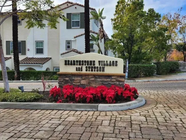a sign board with a house in the background