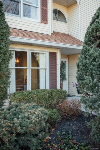 a view of a house with a yard and potted plants