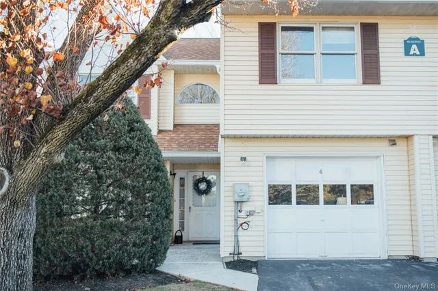 a front view of a house with a tree