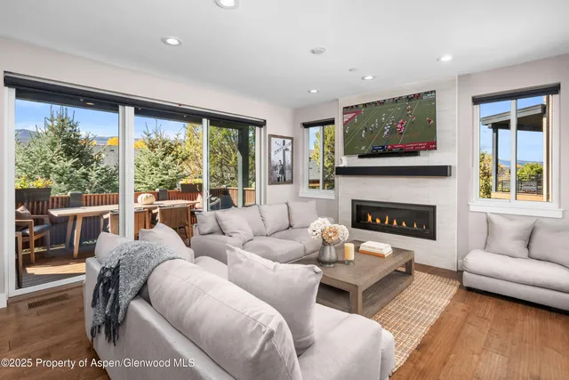 a living room with furniture a large window and a fireplace