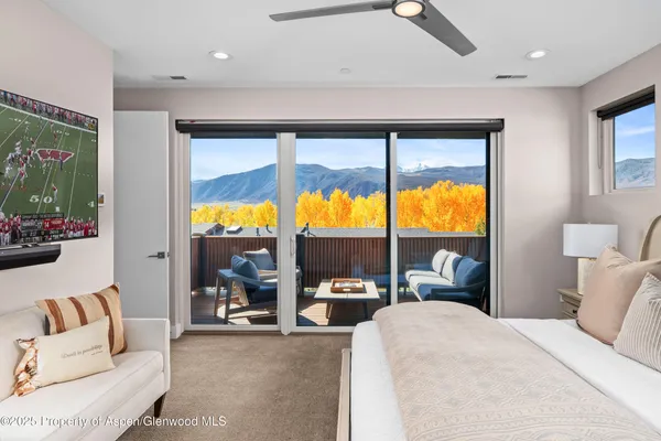 a living room with large windows and a flat screen tv