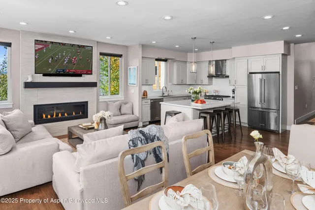 a living room with furniture a flat screen tv and a fireplace