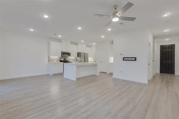 a view of a kitchen with a sink and dishwasher a refrigerator with wooden floor