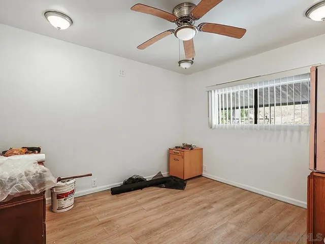 a view of room with hardwood flooring and ceiling fan